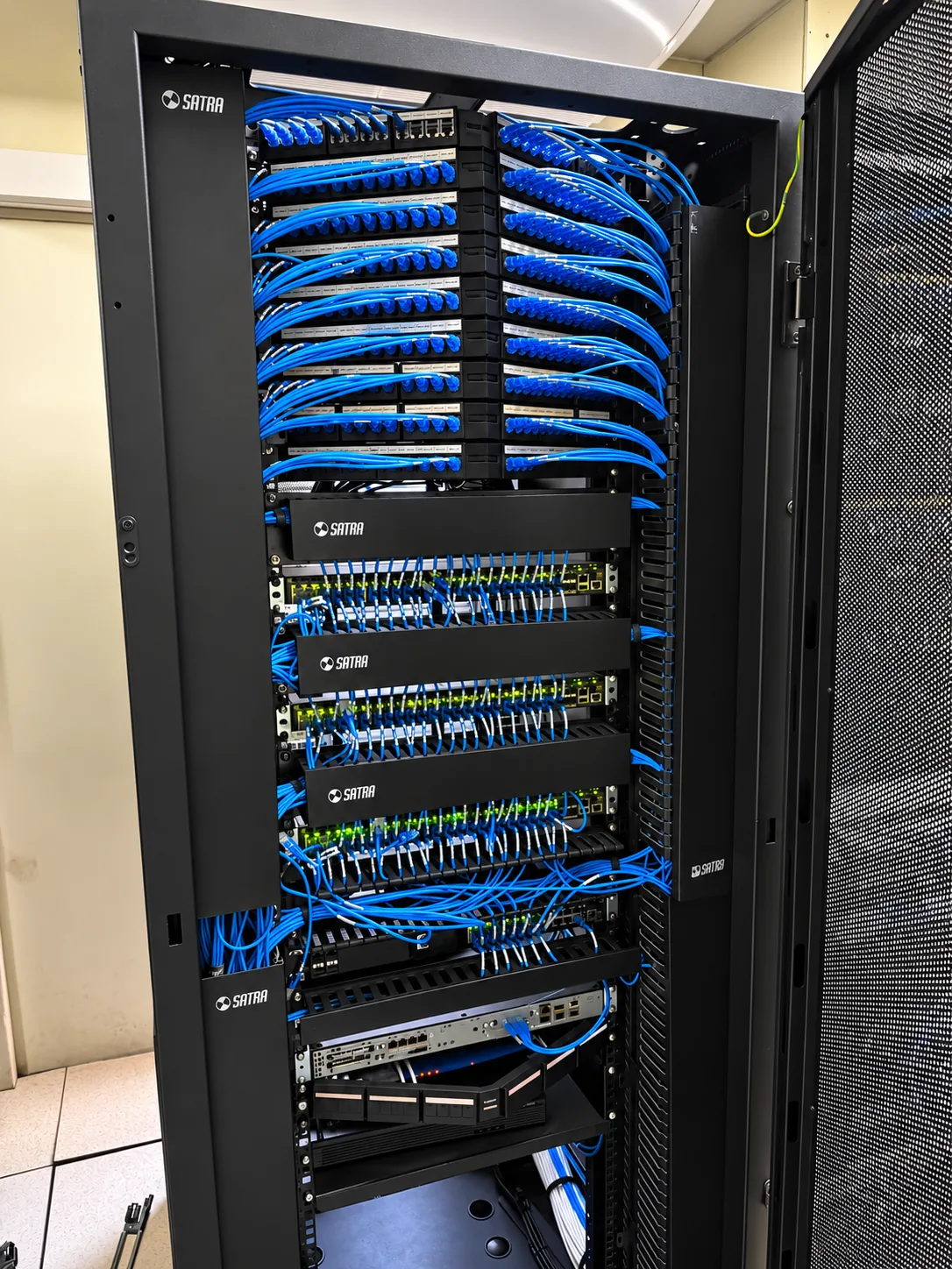 Gabinete de comunicaciones con cableado azul organizado en paneles y switches