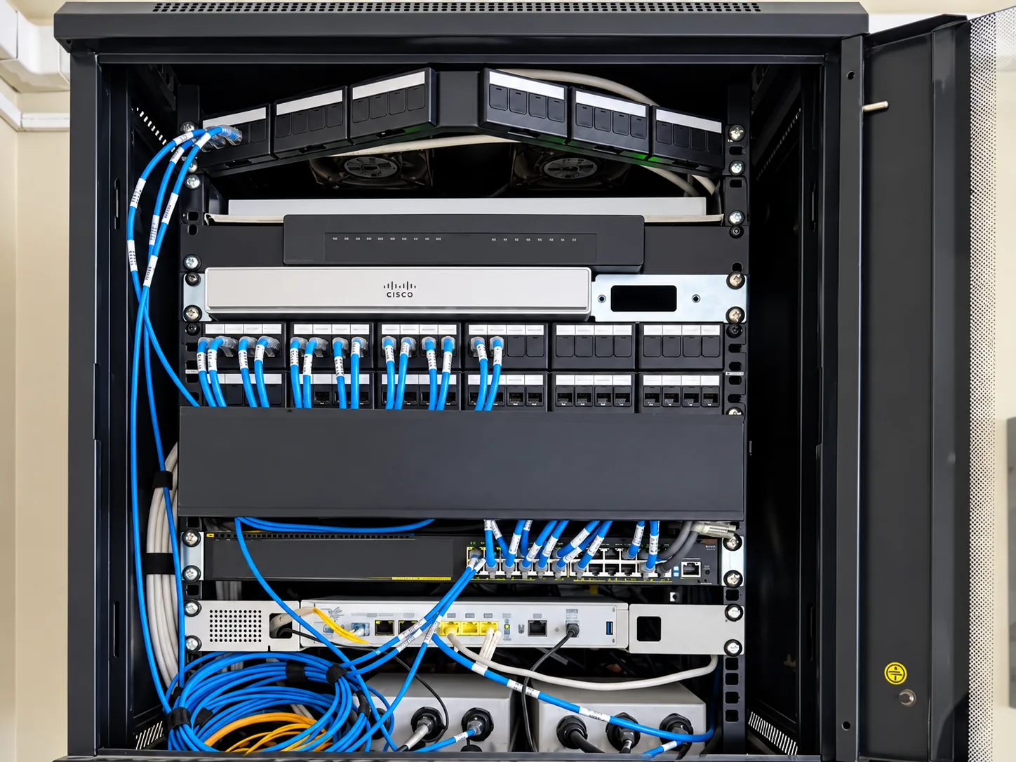 Gabinete de distribución con patch panels, cables de red y equipos de comunicación