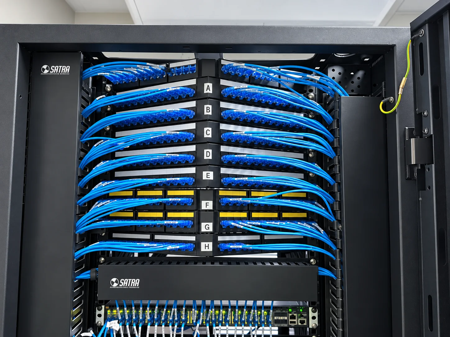 Rack de cableado estructurado instalado por COMPACTNETWORK con paneles y cables de red organizados